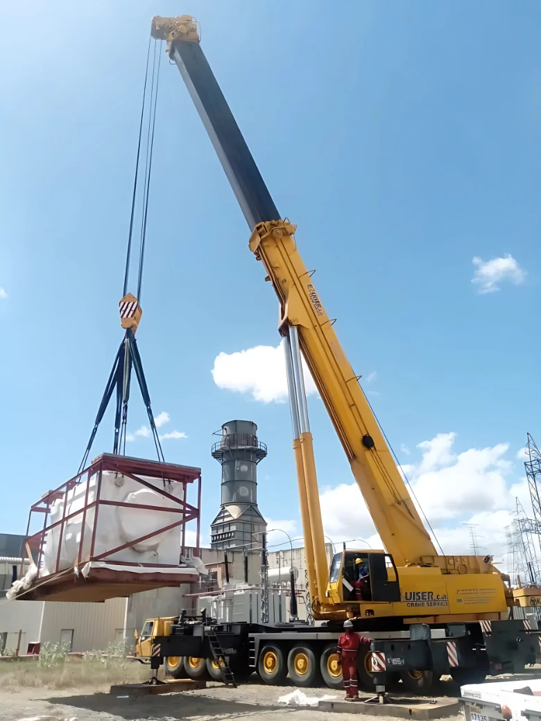 Grúa móvil de 130 toneladas izando transformador eléctrico
