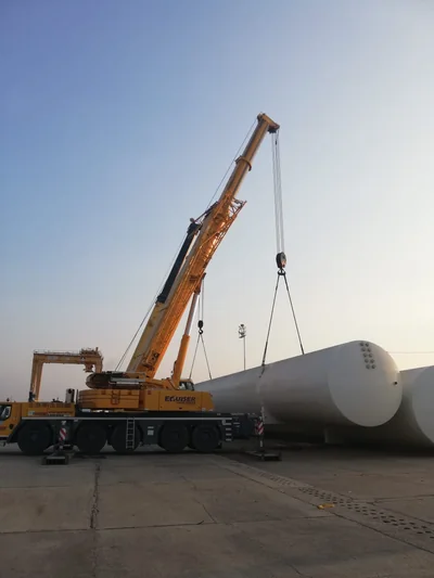 Trabajo Petromonagas con grúa amarilla izando tanque blanco grande
